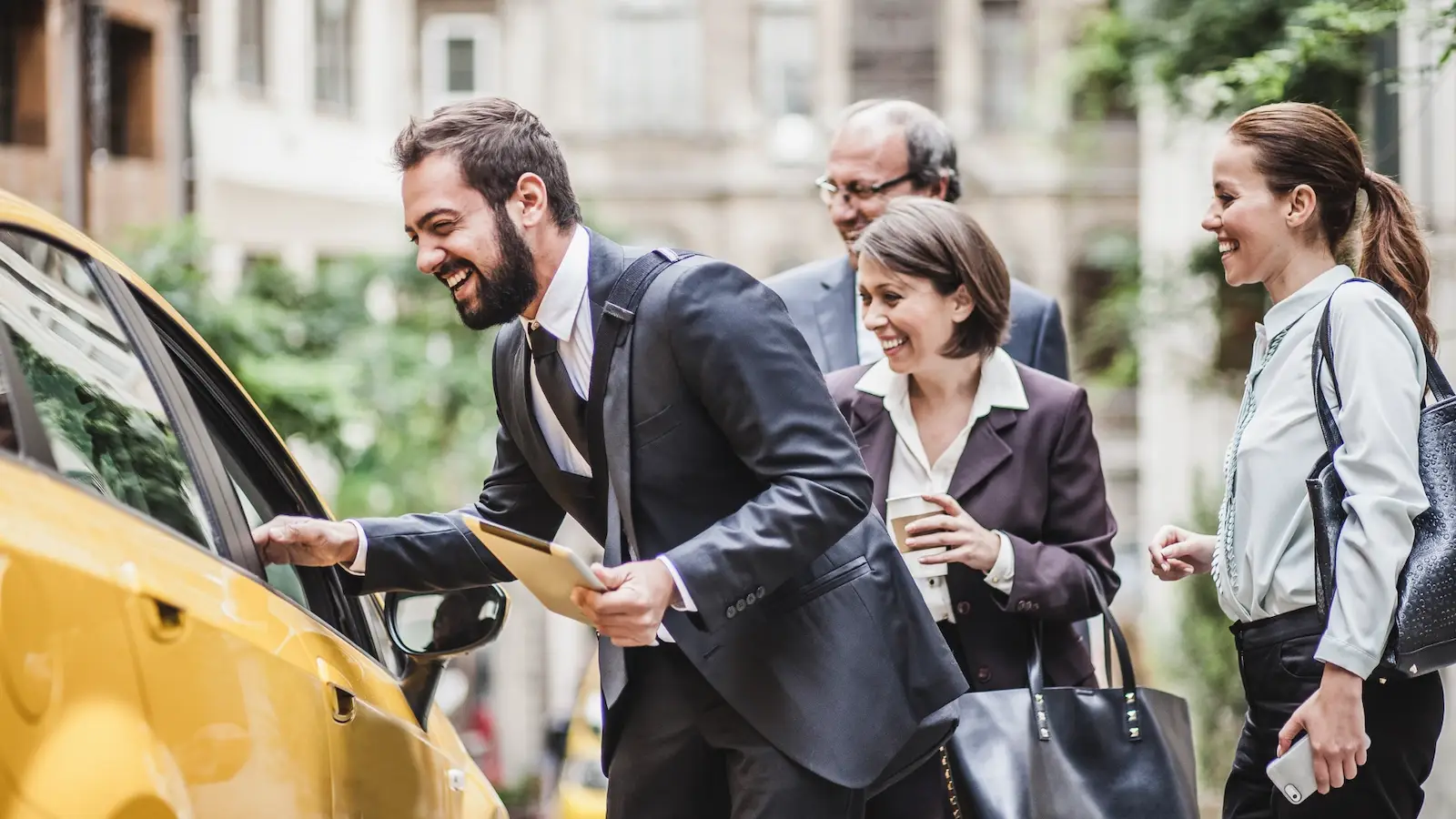 Businesspeople smiling as they board a taxi from Taxi Brussels Airport
